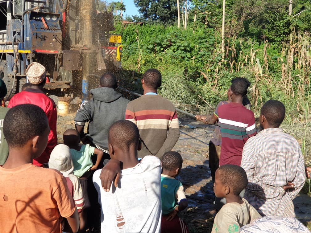 Community members watching work at the Kuze-Kibago borehole site