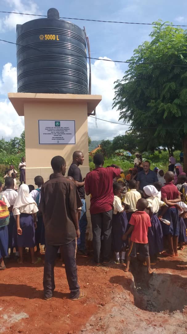 Community members gathered beside the completed Mtoni Bombo water point